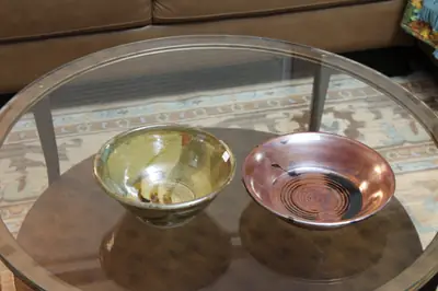 Green and red bowls. A green footed bowl beside a wide rust-red bowl.