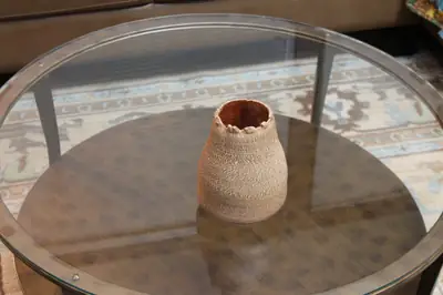 Torn-rim vessel. Small textured vessel with a torn rim.