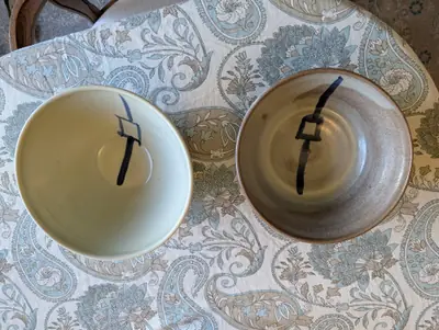Two bowls from above on a paisley tablecloth, one pale porcelain and one brown stoneware, each with a blue lantern motif